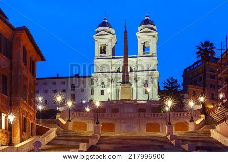 Monumental stairway Spanish Steps, seen from Piazza di Spagna, and Trinita dei Monti church during morning blue hour, Rome, Italy.