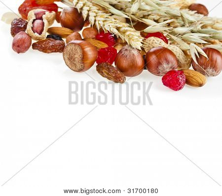 Saudáveis frutas secas e castanhas com espiguetas de aveia e trigo isolado no fundo branco