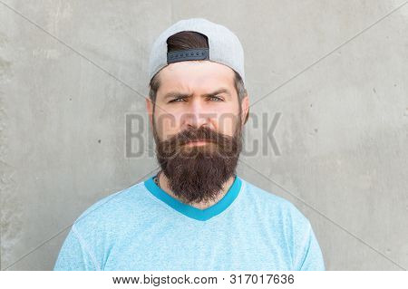 Bearded And Moustached. Bearded Man On Grey Wall. Serious Bearded Hipster In Casual Summer Style. Ca