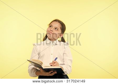 Child School Uniform Kid Doing Homework. Child Girl School Uniform Clothes Hold Book And Pen. Girl C