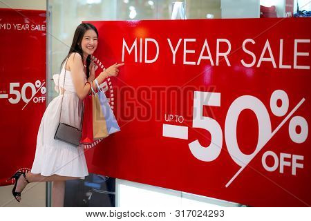 Asian Girl Shopping With Mid Year Sale 50 Percen Off Promotion In Department Store