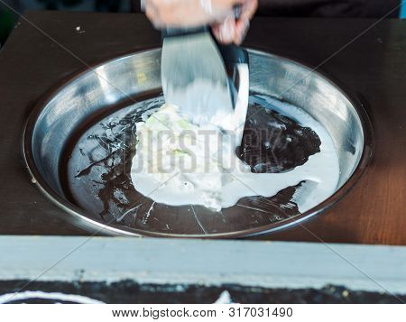 Making Rolled Ice Cream. Man Hands Making Kiwi And Banana Thay Style Natural Ice Cream