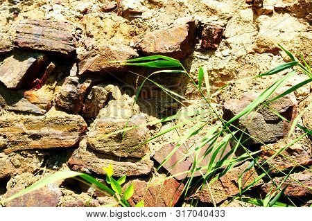 Ancient Wall Made Of Large Stones Of Iron Ore Bonded.