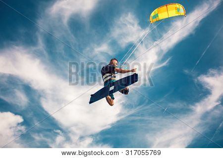 Professional Kiter Makes The Difficult Trick On A Beautiful Background. Kitesurfing Kiteboarding Act