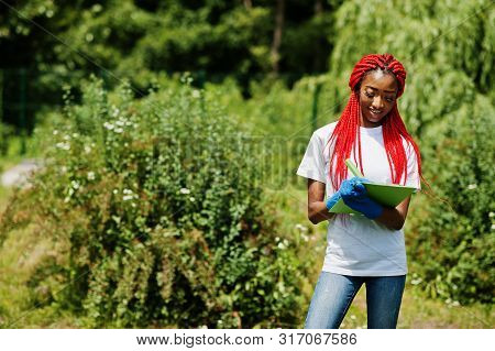African Red Haired Volunteer Woman With Clipboard In Park. Africa Volunteering, Charity, People And