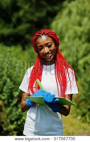 African Red Haired Volunteer Woman With Clipboard In Park. Africa Volunteering, Charity, People And