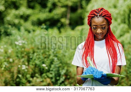 African Red Haired Volunteer Woman With Clipboard In Park. Africa Volunteering, Charity, People And