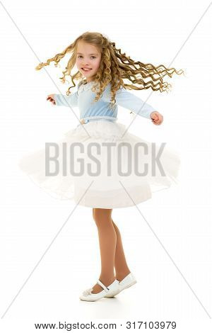 Beautiful Little Girl In A Dress Is Spinning. Concept Of Happy Childhood, Dancing, Holidays. Isolate