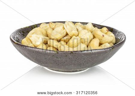 Lot Of Whole Unsalted Beige Cashew In Dark Ceramic Bowl Isolated On White Background