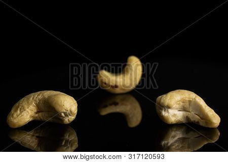 Group Of Three Whole Unsalted Beige Cashew Isolated On Black Glass