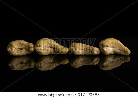 Group Of Four Whole Unsalted Beige Cashew Isolated On Black Glass