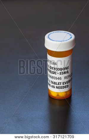 Prescription Bottle With Backlit Oxycodone Tablets. Oxycodone Is A Generic Prescription Opioid. A Co