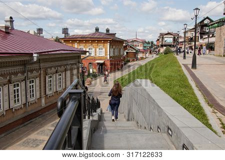 Irkutsk, Russia - August 12, 2019: People Walk Around A Tourist Place - The 130th Quarter. In The Fo