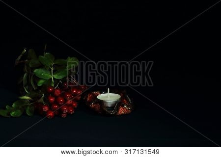 Wax Candle On Original Ceramic Candlestick Decorated With Glaze And Rowan Branch On Dark Background.