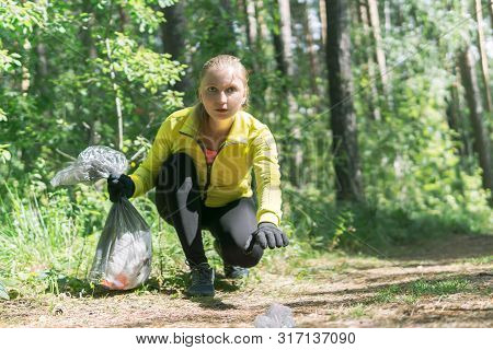 Woman Jogger Leans Over Trash During Plogging