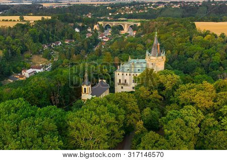 Aerial View Of Old Castle In Green Wood With Old Bridge On The Background
