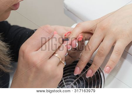 Nail Care - Applying A Base Coat. The Master Applies A Transparent Base Coat To The Clients Nails.