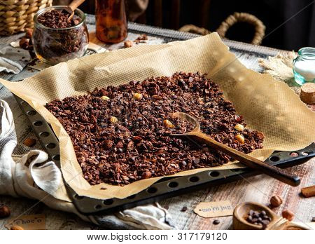 Homemade Baked Chocolate Granola With Nuts, Oat Flakes On Baking Tray With Parchment Stands On Grey 