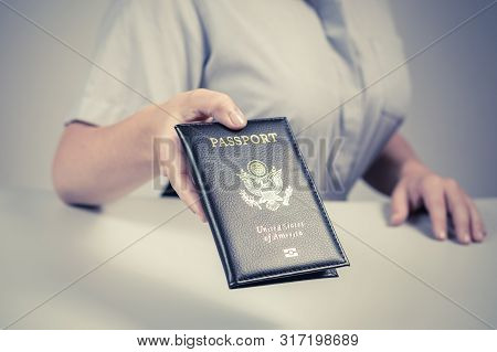 Immigration And Passport Control At The Airport. Woman Border Control Officer With Us Passport Of Am