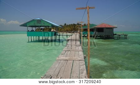 A Pier With Wooden Arbors On A Tropical Island. Onok Island, Balabac, Philippines. Summer And Travel