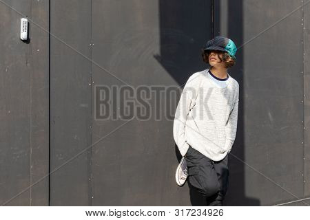 Portrait of boy with colorful hat and black background.