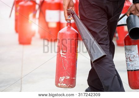 Closeup Of Fireman Lower Body Prepare To Fire Drill By Holding Portable Fire Extinguish And Water Ho