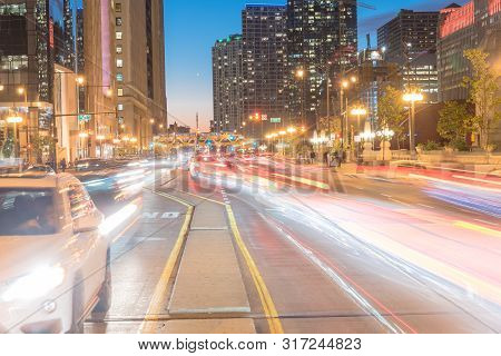 Wacker Dr Street With Tall Buildings And Street Light Trails In Chicago At Night