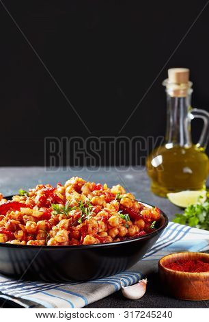 Garbanzos Fritos, Hot Chickpea Stew With Sliced Chorizo, Ham, Tomatoes And Spices In A Black Bowl On
