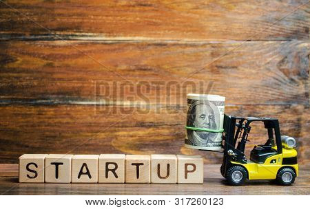 Forklift Truck Carries A Bundle Of Dollars To Inscription Startup. The Concept Of Raising Funds For 