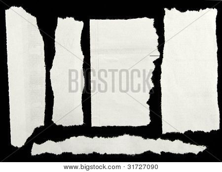 Ein Stück zerrissenes Papier auf schwarz