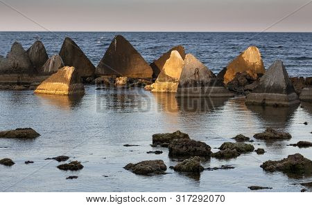 Seascape. Stones And Concrete Pyramids Of Light Before Sunset. Shabla, Northern Black Sea Coast, Bul