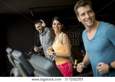 Young People Using Threadmill In Modern Gym