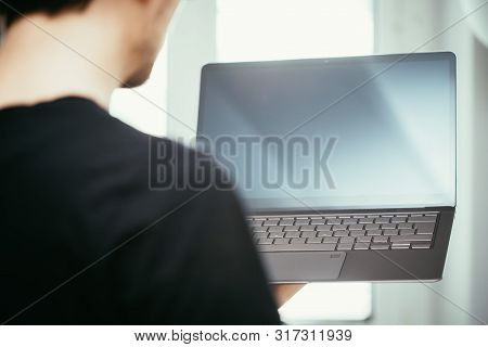 Young Freelancer Is Holding Up A Thin Elegant Notebook
