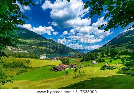 Catholic Church, Traditional Wood And Modern Houses Along The Lake Lungernsee In Swiss Village Lunge