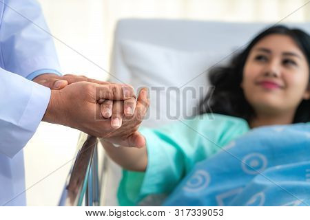 Friendly Man Doctor Hands Holding Patient Hand Sitting At The Desk For Encouragement, Empathy, Cheer