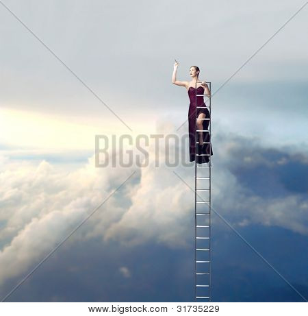 schöne elegante Frau auf einer Leiter in den Himmel zeichnen