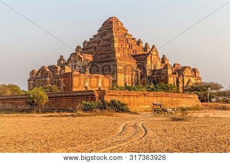 Dhammayangyi Temple At Sunset With Horse Cart Trail On The Ground.
