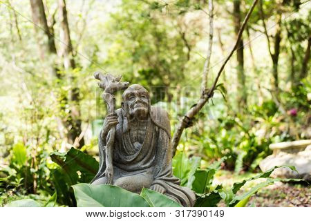stone ruined Arhat statue in forest, Taiwan, Asia