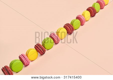 Colored Macaron Or Macaroon, Sweet Meringue-based Confection On Pink Background. Close-up, Copy Spac