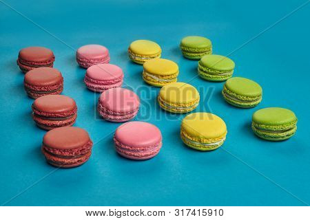 Colored Macaron Or Macaroon, Sweet Meringue-based Confection On Blue Background. Close-up, Copy Spac