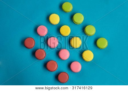 Colored Macaron Or Macaroon, Sweet Meringue-based Confection On Blue Background. Close-up, Copy Spac
