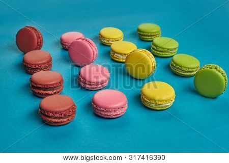 Colored Macaron Or Macaroon, Sweet Meringue-based Confection On Blue Background. Close-up, Copy Spac