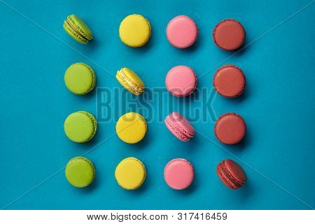 Colored Macaron Or Macaroon, Sweet Meringue-based Confection On Blue Background. Close-up, Copy Spac