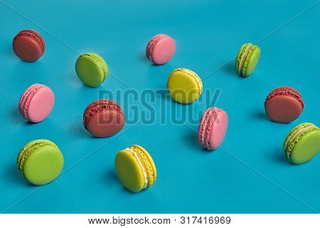 Colored Macaron Or Macaroon, Sweet Meringue-based Confection On Blue Background. Close-up, Copy Spac