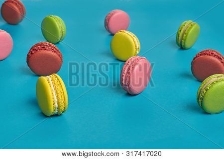 Colored Macaron Or Macaroon, Sweet Meringue-based Confection On Blue Background. Close-up, Copy Spac