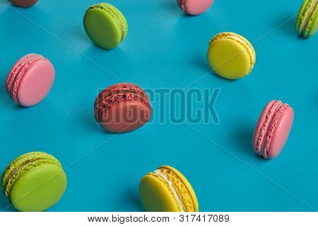 Colored Macaron Or Macaroon, Sweet Meringue-based Confection On Blue Background. Close-up, Copy Spac