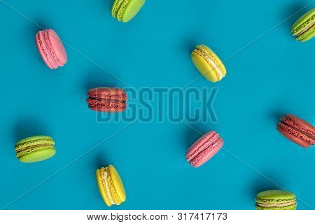 Colored Macaron Or Macaroon, Sweet Meringue-based Confection On Blue Background. Close-up, Copy Spac