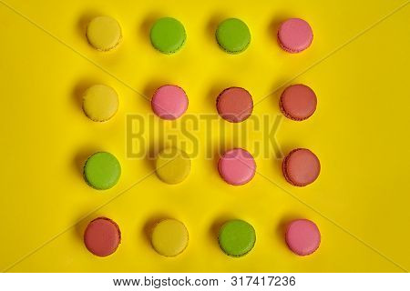 Colored Macaron Or Macaroon, Sweet Meringue-based Confection On Yellow Background. Close-up, Copy Sp