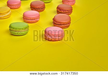 Colored Macaron Or Macaroon, Sweet Meringue-based Confection On Yellow Background. Close-up, Copy Sp
