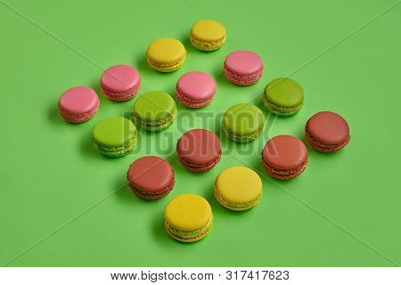 Colored Macaron Or Macaroon, Sweet Meringue-based Confection On Green Background. Close-up, Copy Spa